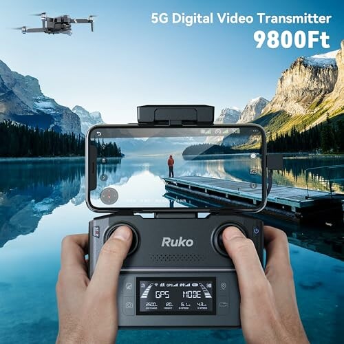 Drone controller with smartphone display showing a scenic mountain lake view.