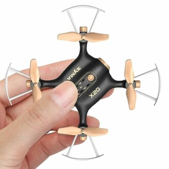 Person holding a small black and gold drone with propeller guards.